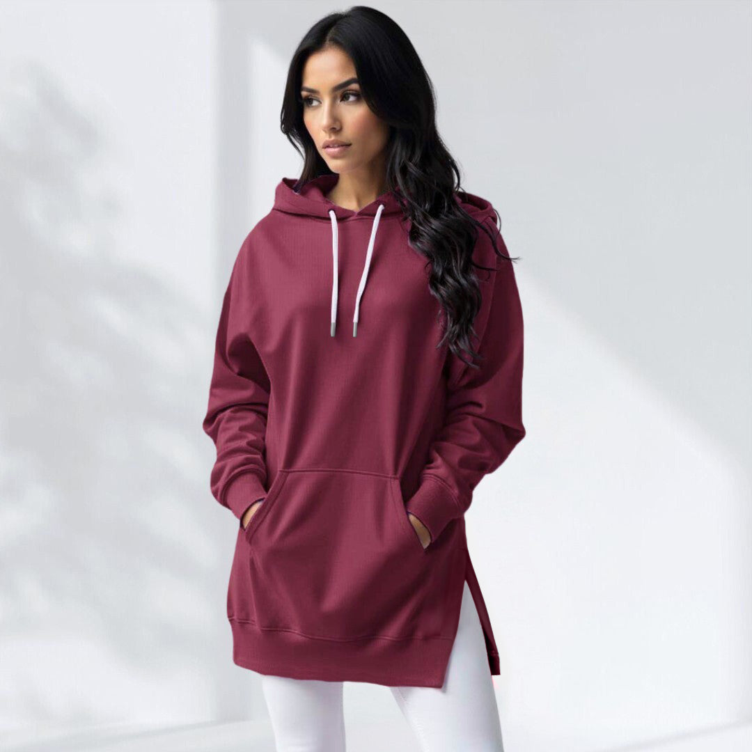 Woman wearing a black hoodie dress with an embroidered dog mom heart on the sleeve, standing and facing forward to show the fit and style.